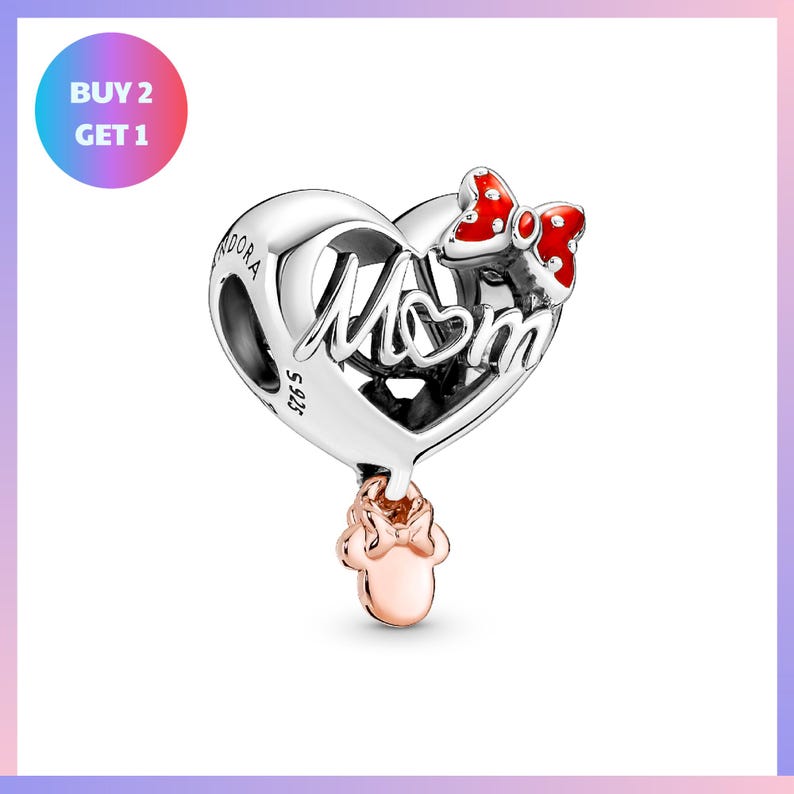 a silver heart-shaped pendant with the word "Mom" written on it, along with a red bow charm. The pendant is displayed against a white background, and there is a promotional offer for the purchase of two pieces of the same item.