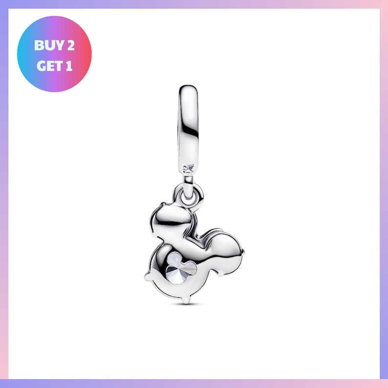 A silver charm in the shape of a Mickey Mouse ear, with a small eye and a small smiley face, hanging from a chain.