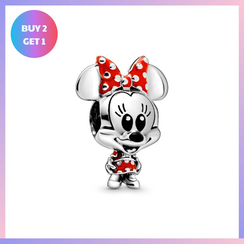 A silver charm in the shape of Minnie Mouse, with red polka dots and a bow, is displayed against a white background.