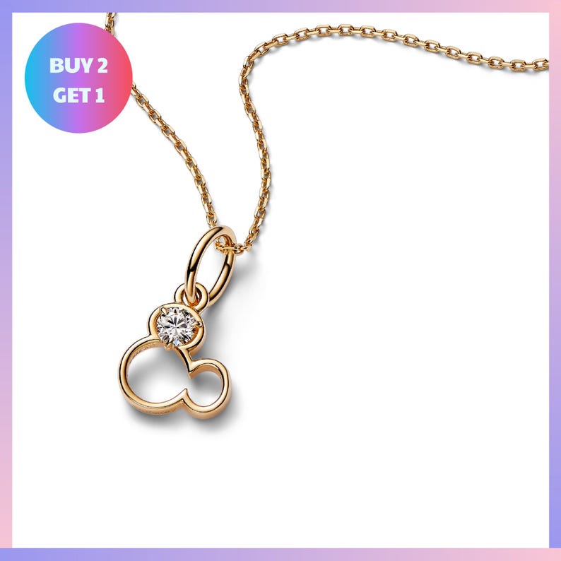 A gold-colored necklace with a pendant featuring a small, clear gemstone.