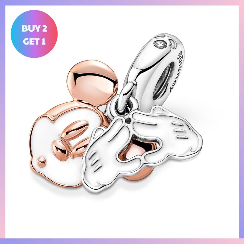 a collection of charms, including a Mickey Mouse charm, a pair of white hand charms, and a silver charm.
