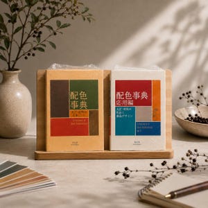 以下が含まれることがあります： 木製スタンドに立てられた「A Dictionary of Color Combinations」というタイトルの2冊の長方形の本。左の本はベージュの表紙に緑、茶、赤のブロックが配置され、右の本は白の表紙に赤、青、灰色のブロックが配置されています。
