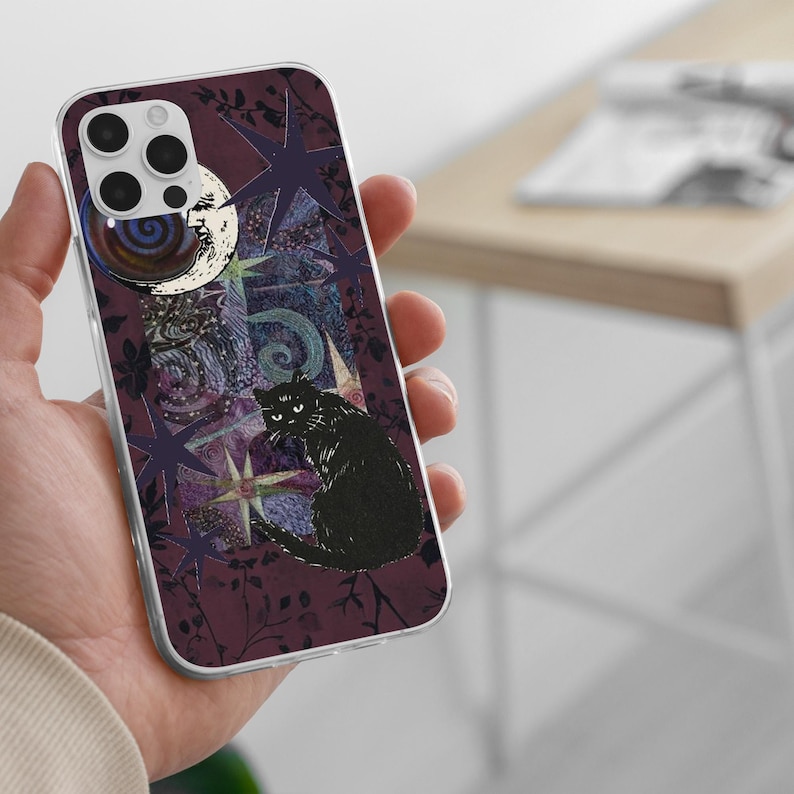 May include: A clear phone case featuring a dark purple background with a black cat illustration, a crescent moon with a face, and various star shapes. The design includes intricate swirling patterns and botanical silhouettes in deep shades of purple.
