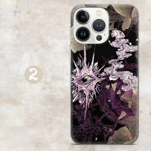 May include: A smartphone case featuring a black background with a central light purple eye graphic surrounded by radiating spikes. The design includes swirling white smoke-like patterns and gold-toned circular line motifs throughout the surface.
