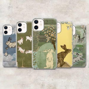 May include: Five smartphone cases featuring various artistic designs. The designs include rabbits, daisies, books, and celestial elements like stars and clouds, rendered in a mix of blue, green, yellow, and cream colour palettes.