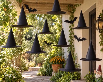 May include: A collection of black witch hats suspended from the ceiling by thin strings, interspersed with black paper bat silhouettes. The hats feature a pointed conical crown and a wide circular brim, creating a floating display.
