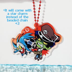 Puede incluir: Un dije de acr&iacute;lico con una ilustraci&oacute;n de dibujos animados de un personaje de pelo azul con m&aacute;scara blanca y un personaje de piel verde con sombrero marr&oacute;n, atados con una cuerda. El texto dice: *It will come with a star charm instead of the beaded chain <3.