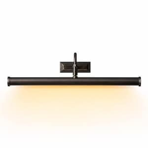 May include: A dark bronze picture light fixture featuring a long, horizontal cylindrical lamp head attached to a rectangular wall-mounting plate by a central arm. The fixture emits a warm, soft, downward-facing glow from its underside.