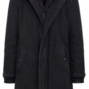 Puede incluir: Un parka negro con capucha, cierre de cremallera, bolsillos abotonados y puños ajustables. El abrigo presenta un diseño en capas con un forro interior visible y un acabado sutilmente desgastado, adecuado para el frío.