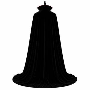 May include: A floor-length black velvet cape featuring a high, stiffened stand-up collar with a deep red inner lining. The garment is displayed on a mannequin, showcasing a full, flowing silhouette that drapes down to the floor in vertical folds.