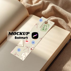 Puede incluir: Un marcapáginas decorativo con fondo beige, con ilustraciones de flores, lazos y un cárdigan. El marcapáginas tiene una cuerda y el texto "MOCKUP Bookmark" es visible. También aparece el logotipo de la aplicación Procreate.