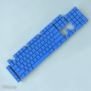 May include: A set of bright blue mechanical keyboard keycaps arranged in a standard layout. The individual keys are blank with a smooth, matte finish. The text EliKeycap is printed in the bottom left corner of the image in a dark grey font.