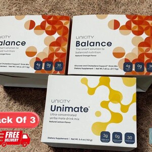 Op de afbeelding: Twee witte dozen Unicity Balance drankmix met oranje geometrische patronen en &eacute;&eacute;n witte doos Unimate yerba mate drankmix met gele abstracte vormen, elk met 30 sticks voor eenmalig gebruik.