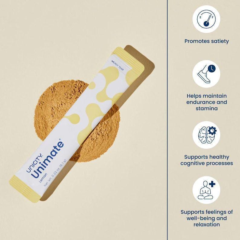 Op de afbeelding: Een Unicity Unimate Lemon drankmix-stick met een wit en geel patroon, liggend op een hoop bruin poeder. De tekst op de verpakking luidt Unicity Unimate Lemon Net Wt. 0.22 oz. (6,1 g). Vier ronde iconen tonen voordelen: verzadiging, uithoudingsvermogen, cognitie en welzijn.