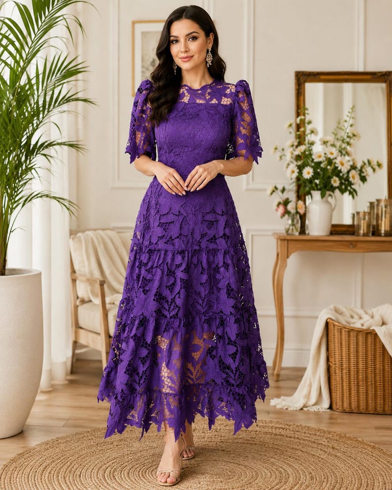May include: A vibrant purple midi dress featuring intricate floral lace detailing throughout. The garment has short puff sleeves, a round neckline, and a tiered skirt with a scalloped hemline. The lace pattern is dense and covers the entire dress.