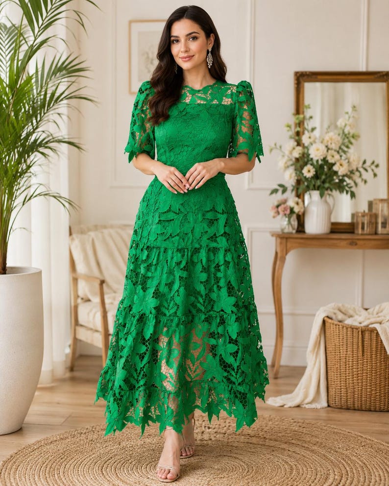 May include: A vibrant green midi dress featuring intricate floral lace detailing, short puff sleeves, a round neckline, and a tiered skirt with a scalloped hemline. The garment is constructed with a solid lining underneath the lace overlay.
