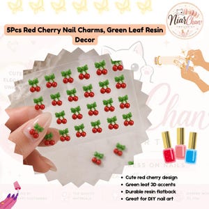 May include: A set of 5 pieces of red cherry nail charms with green leaf resin decor. The charms feature a 3D design of two small red spheres attached to a green leaf element. These flatback resin decorations are intended for application on fingernails.