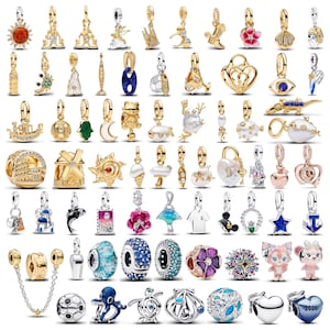 Könnte beinhalten: Eine Sammlung goldfarbener Charm-Anhänger mit verschiedenen Designs, darunter eine Sonne, der Eiffelturm, Tiere und florale Motive. Einige Charms weisen Edelsteine und aufwendige Details auf, geeignet für Armbänder oder Halsketten.