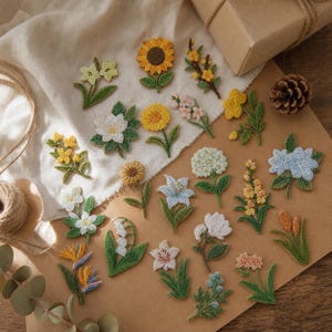 May include: A collection of various embroidered flower patches featuring diverse botanical designs in shades of yellow, white, blue, and green. Each patch displays intricate thread work depicting individual blossoms, stems, and leaves arranged on a surface.