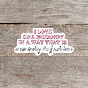 May include: A die-cut sticker featuring the text I LOVE ILYA ROZANOV IN A WAY THAT IS concerning to feminism. The first three lines are in a bold, pink, sans-serif font, while the final line is in a black, cursive, script-style font.