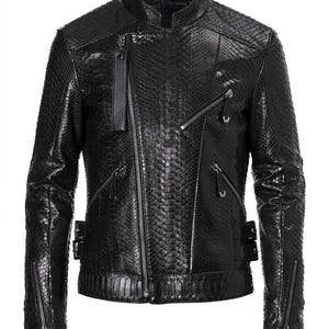 May include: A black jacket featuring a textured snakeskin pattern throughout. The garment includes a stand-up collar, an asymmetrical front zipper closure, multiple zippered pockets on the chest and sides, and adjustable buckle straps at the waist.
