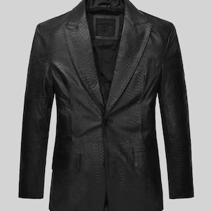 May include: A black blazer featuring a textured snakeskin pattern throughout the fabric. The garment includes a notched lapel, a single-button front closure, and two flap pockets positioned at the lower front. The interior is lined in black.