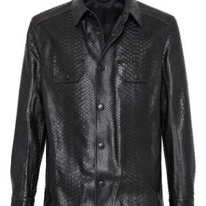 May include: A black long-sleeve shirt featuring a textured snakeskin pattern throughout. The shirt includes a classic collar, a front button-down closure with matte black buttons, and two chest pockets with buttoned flaps on the front panels.