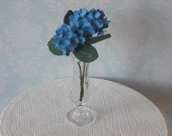 2 blue hydrangeas in handblown glass vase