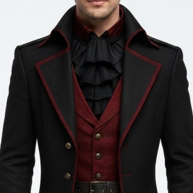 May include: A black coat with dark red piping along the lapels, worn over a dark red vest with metallic buttons. Underneath is a black shirt featuring a layered, ruffled jabot collar. The ensemble includes a black belt at the waistline.