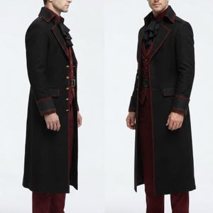 May include: A long black coat with red piping, featuring a high collar, structured shoulders, and gold-toned buttons. Underneath is a dark red vest and a black ruffled cravat. The coat has long sleeves with wide cuffs and a knee-length hemline.