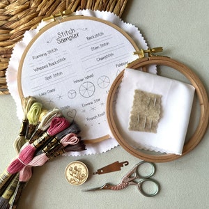 Puede incluir: Un kit de bordado con dos aros de madera, un trozo de tela blanca, un peque&ntilde;o trozo de fieltro con agujas, un peque&ntilde;o bot&oacute;n de madera con un dise&ntilde;o floral, un par de tijeras de bordar, un enhebrador de agujas y un paquete de hilo de bordar en varios colores.
