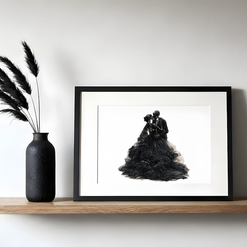 May include: A black framed print featuring an illustration of two skeletons embracing, one wearing a voluminous black gown with floral details and the other in a black suit. Beside the frame stands a black vase containing black dried grass.