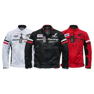 Può includere: Tre giacche da moto in bianco, nero e rosso. Ogni giacca presenta un colletto alto, una cerniera frontale a tutta lunghezza e maniche lunghe con strisce rosse e bianche. Sul petto sono visibili il logo Honda Racing e il marchio HRC.