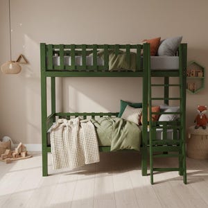 May include: A green bunk bed with a ladder, featuring a top bunk with pillows and a bottom bunk with a blanket. The room has a neutral color scheme with a tree decal on the wall and a stuffed fox.
