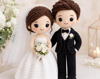 May include: Two crochet dolls representing a wedding couple. The figure on the left wears a white strapless dress, a veil with pearl-like accents, and holds a bouquet of white flowers. The figure on the right wears a black suit with a white shirt, black bowtie, and a white flower boutonniere.