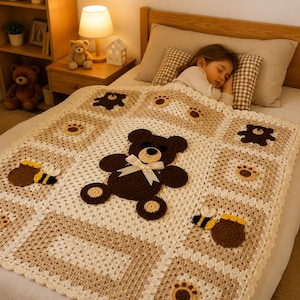 May include: A handmade crochet blanket with a teddy bear theme. The blanket features a large brown teddy bear with a cream-colored bow, paw prints, and bees with honey pots. The color palette includes cream, brown, and beige.