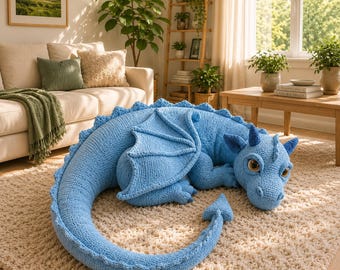 May include: A large, light blue crocheted dragon plush toy with a long, curved tail, textured wings, and prominent brown eyes. The creature is crafted from soft yarn, featuring a detailed scale-like pattern along its back and a pointed tail tip.