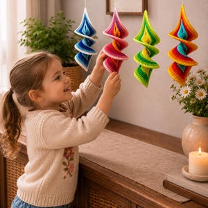 Puede incluir: Cuatro adornos colgantes en espiral hechos de hilo de ganchillo. El primero es azul y blanco, el segundo presenta tonos de rosa y rojo, el tercero es verde lima brillante y el cuarto muestra un degradado de arco&iacute;ris amarillo, naranja y rojo.