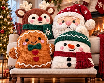 May include: Four plush crochet pillows featuring holiday characters: a brown reindeer with a green scarf, a Santa Claus with a red hat, a gingerbread person with a green bow tie, and a white snowman wearing a green hat and red scarf.