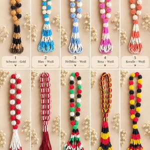 Può includere: Dieci collane di perline con nappe, ognuna con motivi di colore distinti tra cui nero e oro, blu e bianco, rosa e bianco, corallo e bianco, rosso e bianco, rosso e bianco a righe, rosso verde bianco e nero, nero rosso e giallo, e giallo rosso e nero.