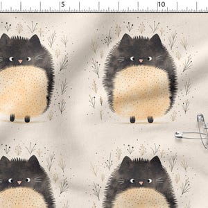 Peut inclure: Tissu avec un motif répété de chats noirs stylisés avec des ventres beiges et de petites pattes noires. Les chats sont placés sur un fond beige avec de petites illustrations de plantes. Quelques épingles de sûreté sont visibles.