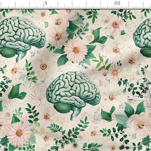 Pode incluir: Um padrão de tecido com um design repetitivo de cérebros anatómicos verde-claros intercalados com flores cor-de-rosa pálido e folhagem verde sobre um fundo creme, com uma régua metálica que mostra uma escala de 38 cm na borda superior.