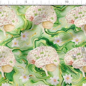 Può includere: Un motivo in tessuto con illustrazioni ripetute di cervelli umani e fiori bianchi su uno sfondo marmorizzato verde con venature dorate. Una spilla da balia argentata è fissata sull'illustrazione del cervello in basso a destra.