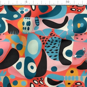 May include: Abstract fabric design with organic shapes in teal, black, pink, orange, and white on a red backdrop. The pattern includes diverse shapes and designs, with safety pins on the fabric.