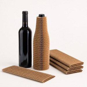 Op de afbeelding: Een donkere glazen wijnfles naast een fles die is omwikkeld met een bruine beschermende kartonnen hoes met honingraatstructuur. Verschillende extra platte, rechthoekige vellen van hetzelfde bruine, rekbare honingraatpapier liggen ernaast.