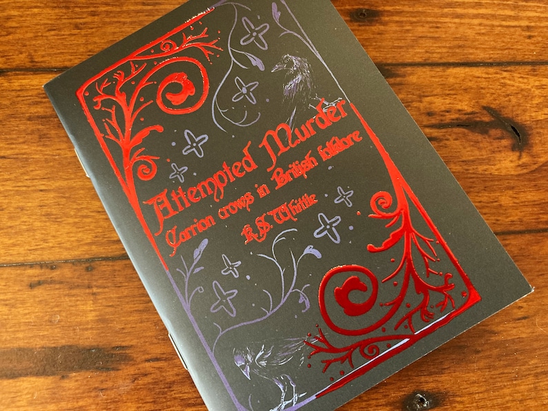 May include: A black book cover with a red and purple design. The title of the book is "Attempted Murder: Carrion Crows in British Folklore" by R.S. Whittle.