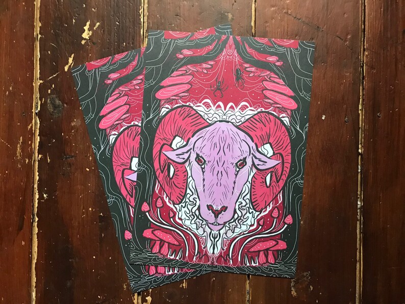Puede incluir: Una cabeza de carnero rosa y blanca con grandes cuernos est&aacute; rodeada de setas rojas y blancas en un entorno de bosque oscuro. El fondo es rojo oscuro y negro con un dise&ntilde;o de telara&ntilde;a.