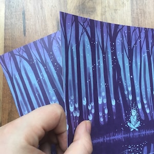 May include: A purple and blue illustration of a forest with a small figure sitting in the center. The figure is surrounded by glowing white orbs and the forest is filled with white dots.