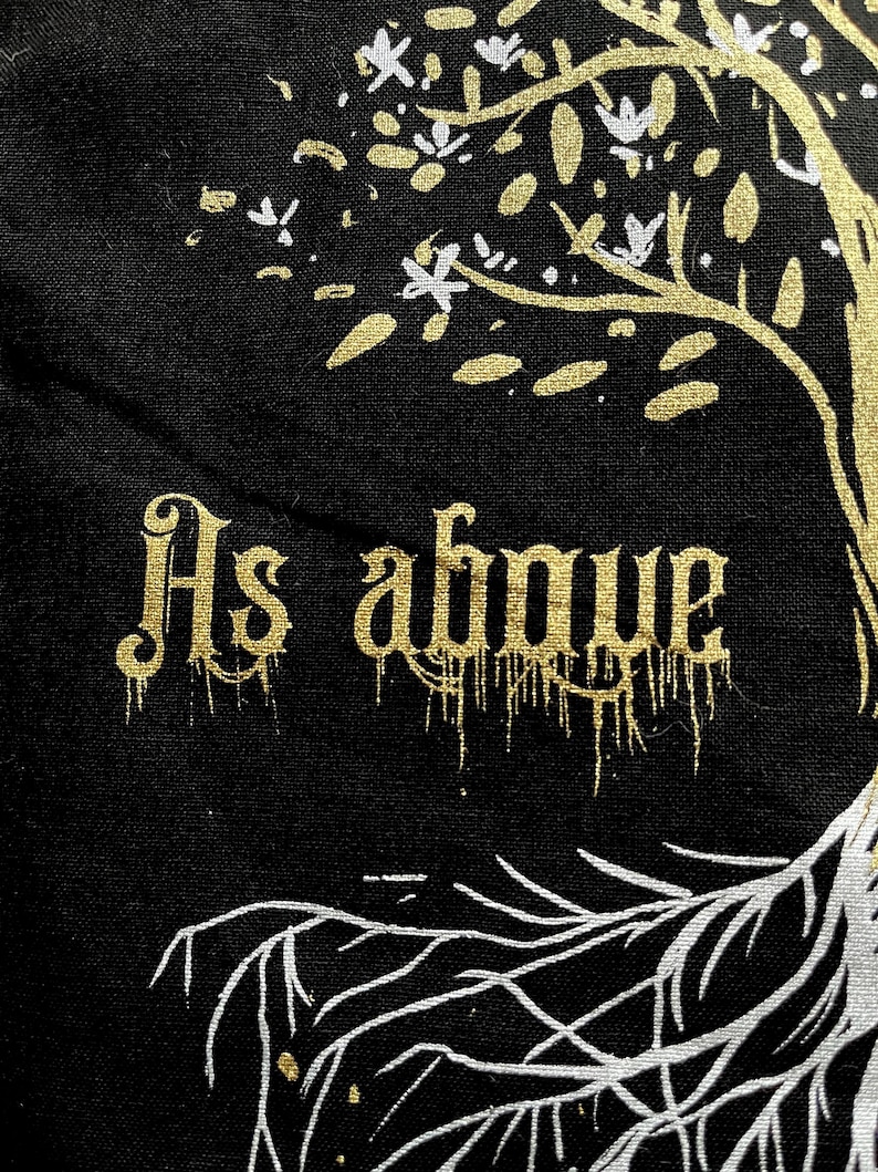 May include: A black canvas tote bag with a gold tree design and the words "As above" in gold lettering.
