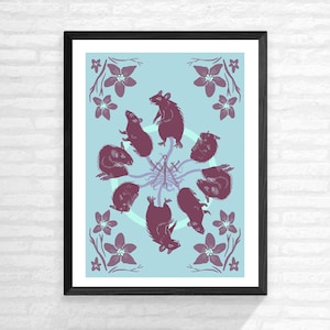 May include: A framed print with a blue background featuring a circle of eight purple rats with floral accents.
